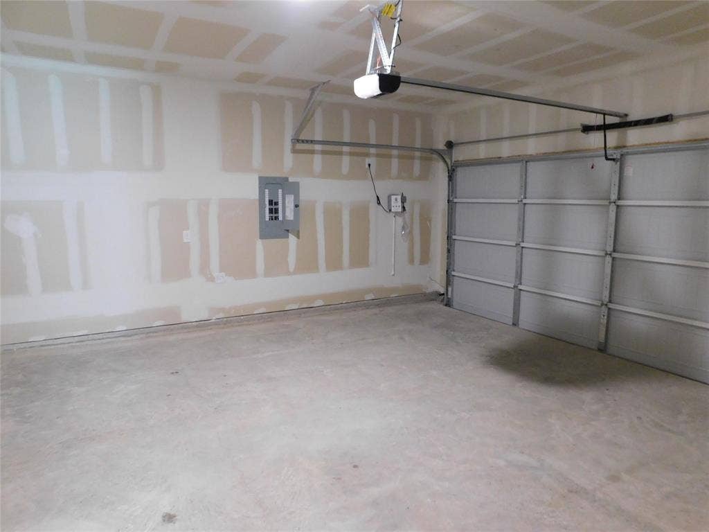 2702 Baynes Place, Princeton, TX 75407 Multi-car garage featuring a concrete floor, sectional overhead garage door, and automatic door opener