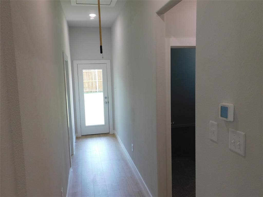 2702 Baynes Place, Princeton, TX 75407 Hallway featuring light-toned wood-finish flooring, recessed lighting, and a glass-panel exterior door