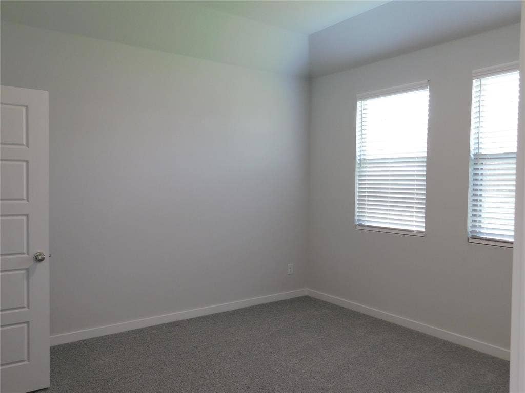 2702 Baynes Place, Princeton, TX 75407 Neutral interior room featuring plush carpeted flooring, two windows with horizontal blinds, and a paneled door