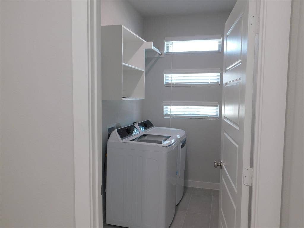 2702 Baynes Place, Princeton, TX 75407 Utility room featuring tile flooring, stacked horizontal windows with blinds, and built-in white shelving with a hanging rod
