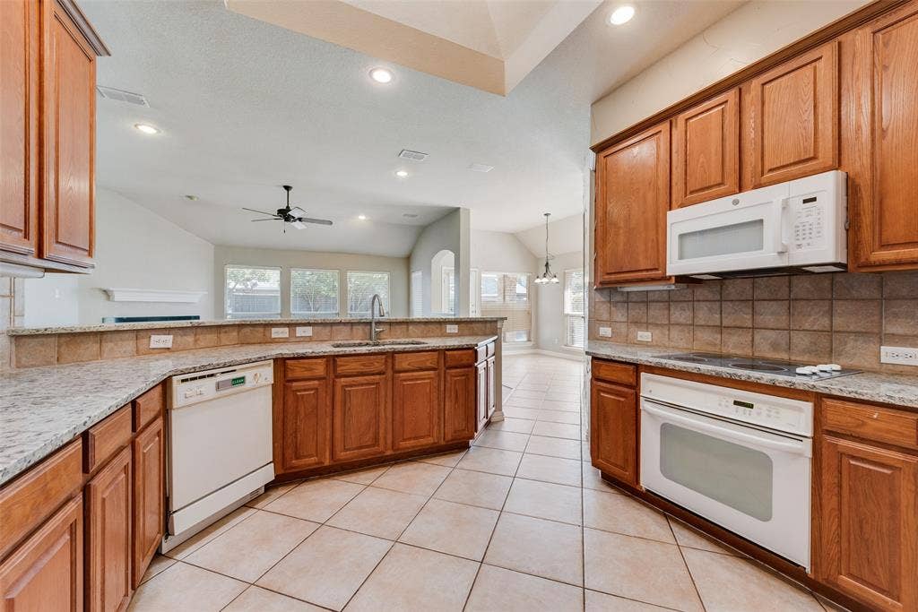 7900 Brookmount Street, Plano, TX 75024 Kitchen featuring wood cabinetry, stone countertops, square tile backsplash, tile flooring, and recessed lighting