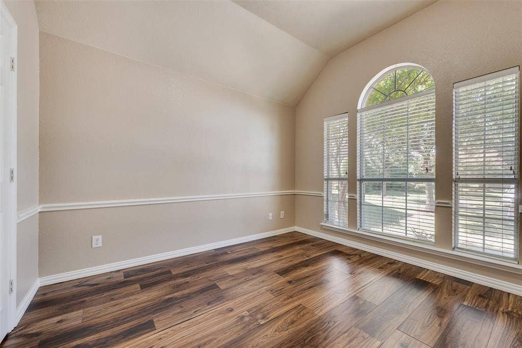 7900 Brookmount Street, Plano, TX 75024 Vaulted ceiling featuring an arched window, wood-finish flooring, and chair rail molding