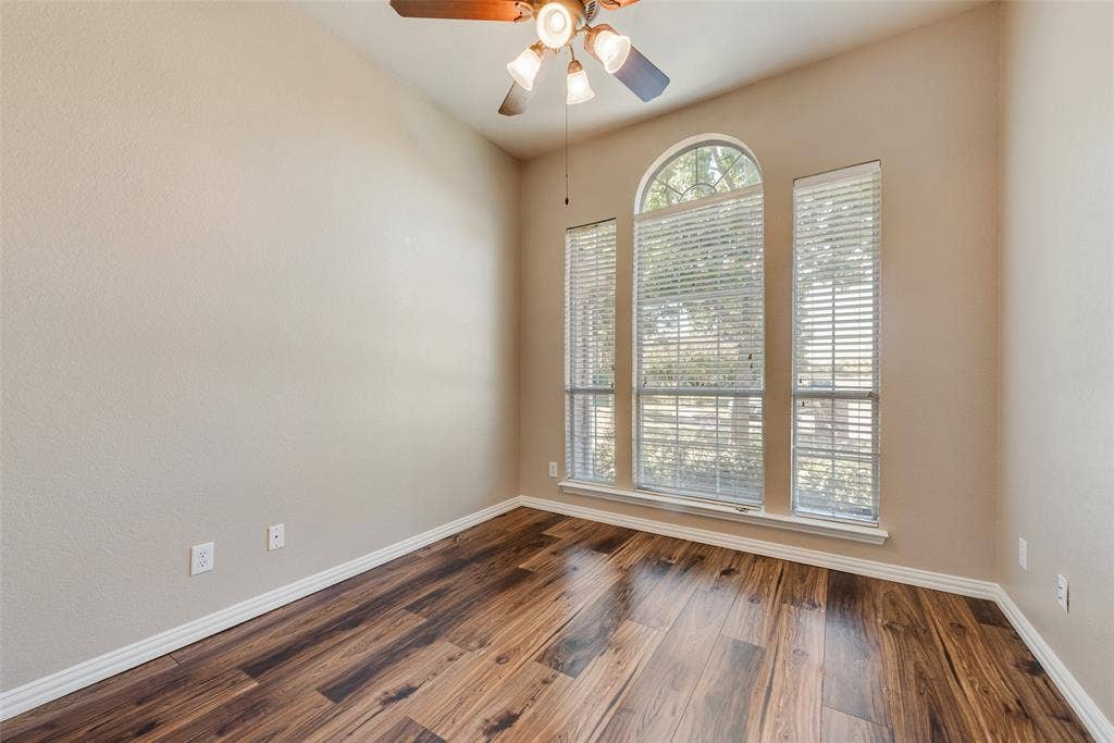 7900 Brookmount Street, Plano, TX 75024 High ceilings featuring an arched window configuration, wood-finish flooring, and a multi-bulb ceiling fan with integrated lighting