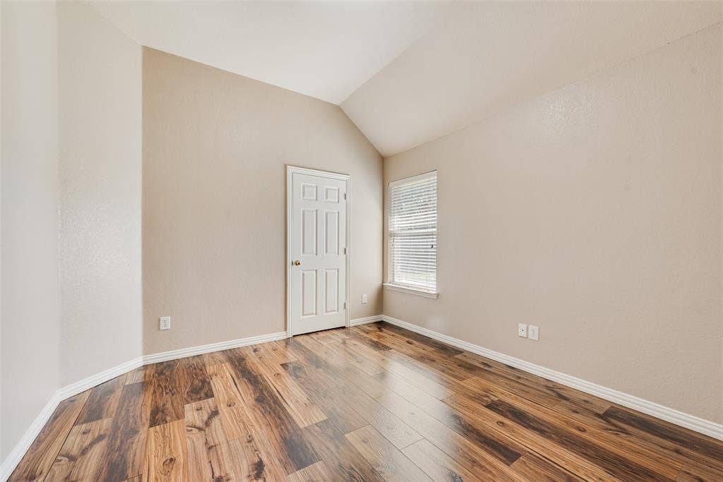7900 Brookmount Street, Plano, TX 75024 Vaulted ceilings, wood-finish flooring, six-panel interior door, and window with integrated blinds