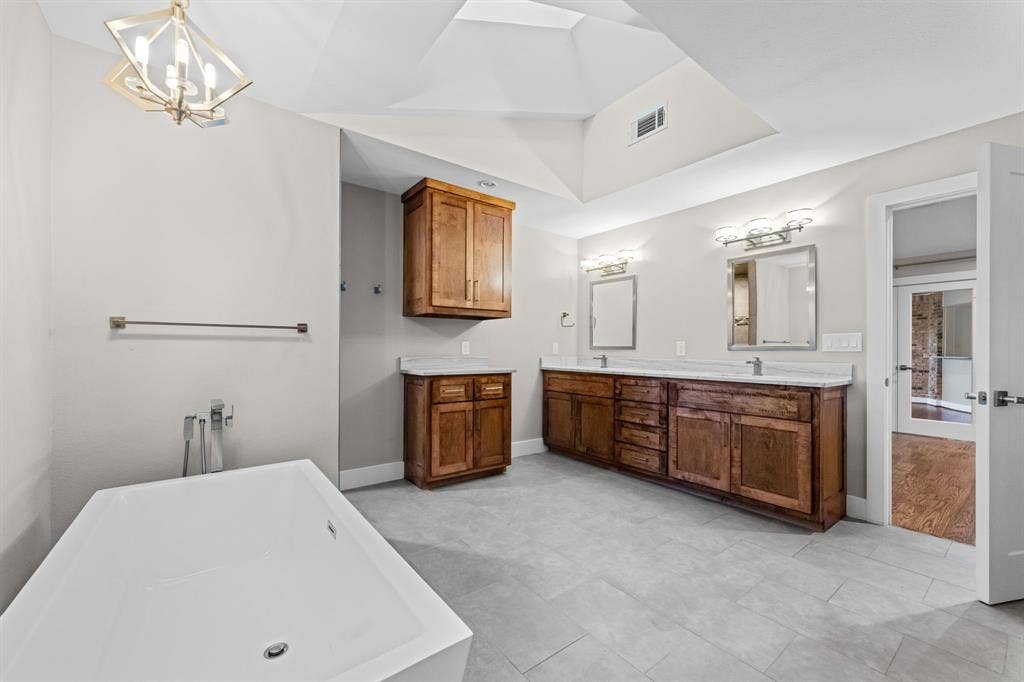 9656 Ravensway Drive, Dallas, TX 75238 Ensuite primary bathroom features an oversized vanity with 2 sinks and a soaking tub