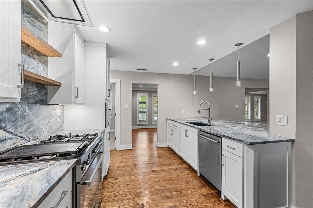 9656 Ravensway Drive, Dallas, TX 75238 Kitchen featuring white shaker cabinetry is open to the front of the home
