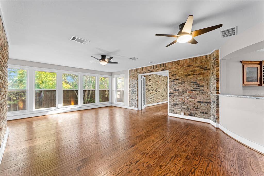 9656 Ravensway Drive, Dallas, TX 75238 The second living area featuring exposed brick walls, windows to the backyard and dual ceiling fans