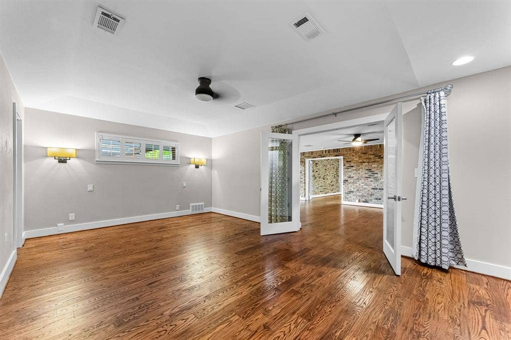 9656 Ravensway Drive, Dallas, TX 75238 The primary bedroom is off the second living room and features a ceiling fan and sconces
