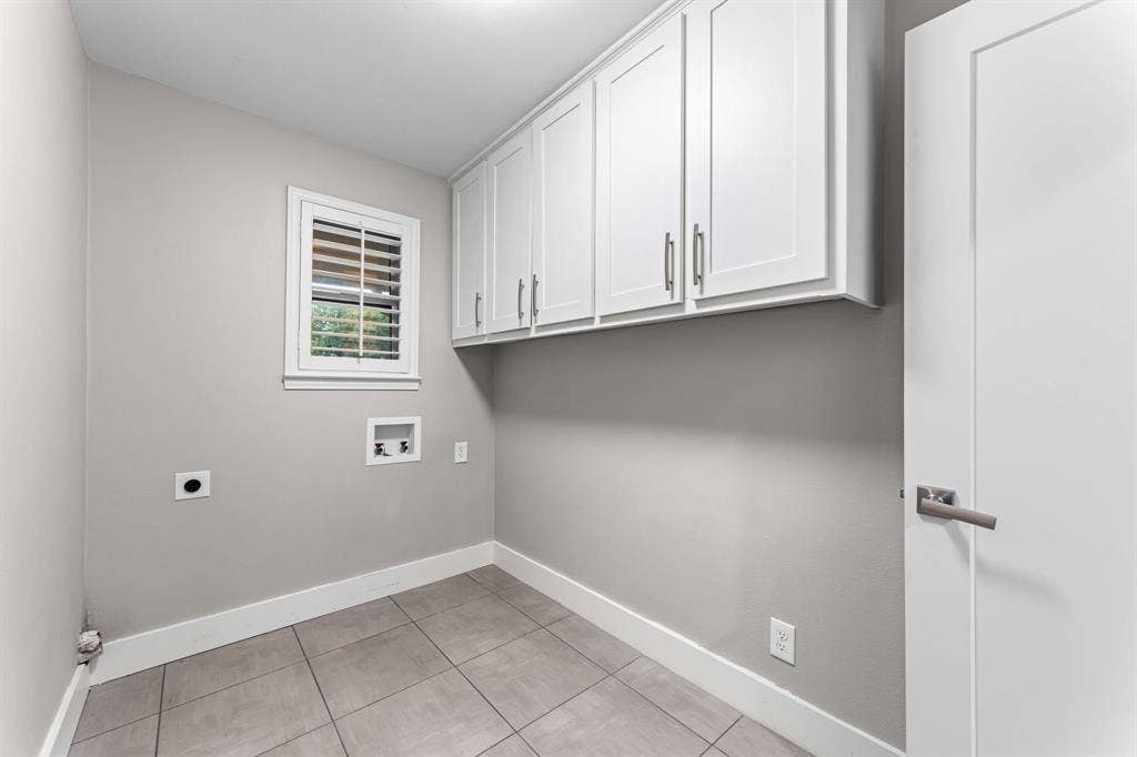 9656 Ravensway Drive, Dallas, TX 75238 Laundry room featuring cabinets and full size washer and dryer connections.