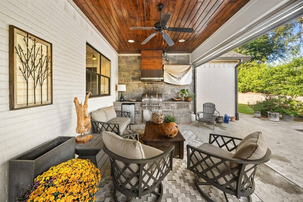 7609 Timber Trail, Tyler, TX 75703 Covered patio featuring a stained wood plank ceiling, stone masonry wall, built-in outdoor kitchen with a stainless steel grill, and integrated recessed lighting