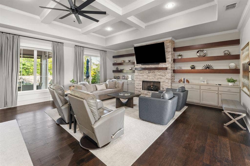 7609 Timber Trail, Tyler, TX 75703 Living area featuring wood-finish flooring, coffered ceiling, stone-surround fireplace, and built-in cabinetry with floating wood shelving