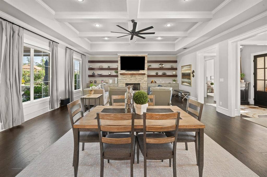 7609 Timber Trail, Tyler, TX 75703 Coffered ceiling with recessed lighting, stone fireplace, custom wood-finish floating shelves, and dark wood-finish flooring