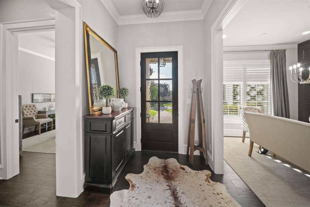 7609 Timber Trail, Tyler, TX 75703 Entryway featuring dark-stained wood flooring, a multi-pane glass door, crown molding, and a decorative ceiling fixture