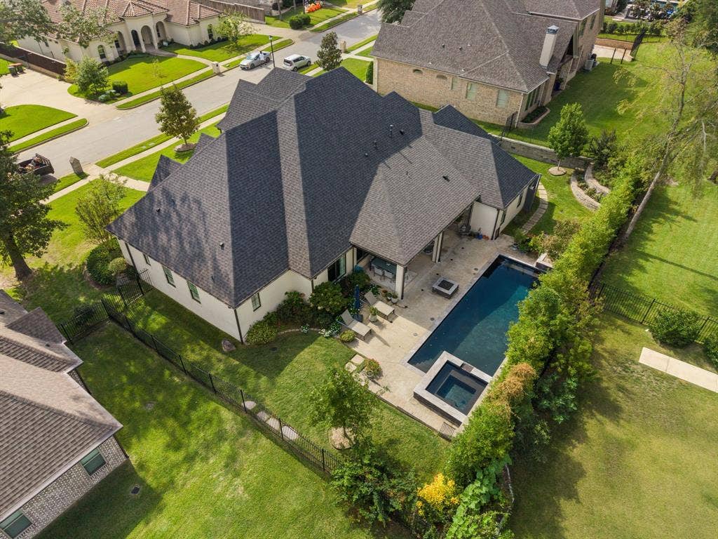 7609 Timber Trail, Tyler, TX 75703 Multi-faceted roofline, covered rear patio, inground pool, integrated spa, and fenced backyard with manicured lawn
