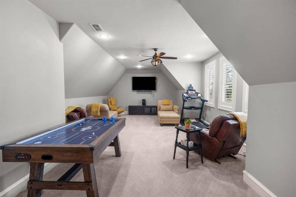 7609 Timber Trail, Tyler, TX 75703 Expansive room featuring vaulted ceilings, neutral wall-to-wall carpeting, recessed lighting, a ceiling fan with integrated light fixture, and plantation shutters
