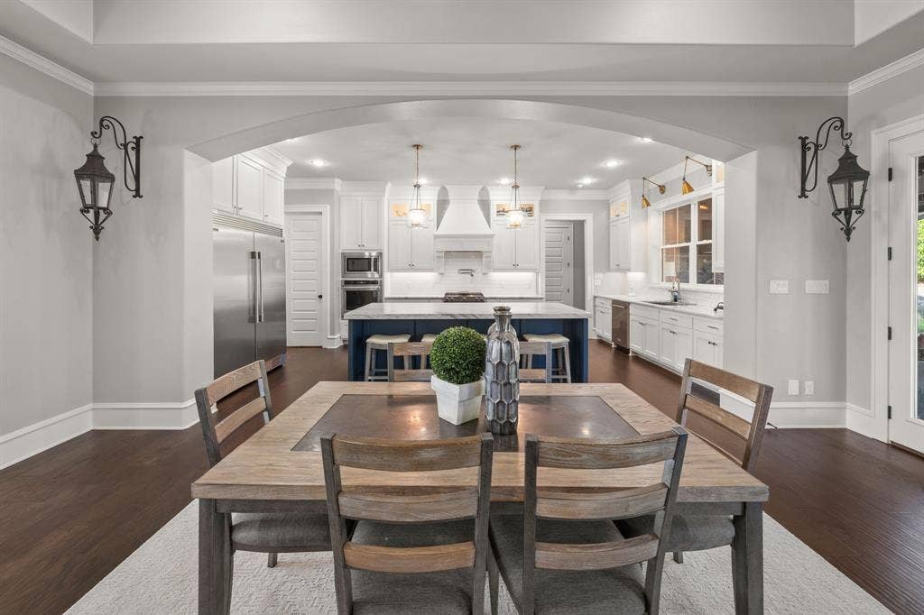 7609 Timber Trail, Tyler, TX 75703 Kitchen area featuring an oversized central island with a contrasting base, white shaker-style cabinetry, stainless steel appliances, recessed ceiling lighting, and dark wood-finish flooring