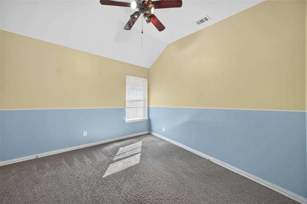 5726 Remington Drive, Garland, TX 75044 Vaulted ceiling room featuring neutral carpeting, a central multi-blade ceiling fan, and a single window with horizontal blinds