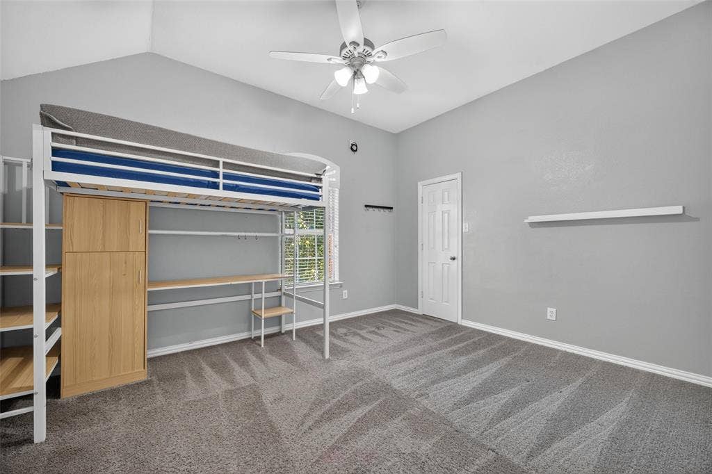 5726 Remington Drive, Garland, TX 75044 Vaulted ceilings, neutral carpeting, a ceiling fan with integrated lighting, and a wall-mounted floating shelf
