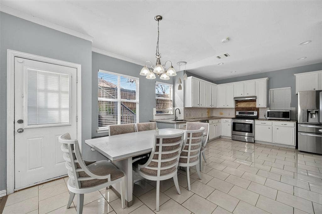 5726 Remington Drive, Garland, TX 75044 Kitchen featuring white cabinetry, stainless steel appliances, tile flooring, and a multi-arm chandelier