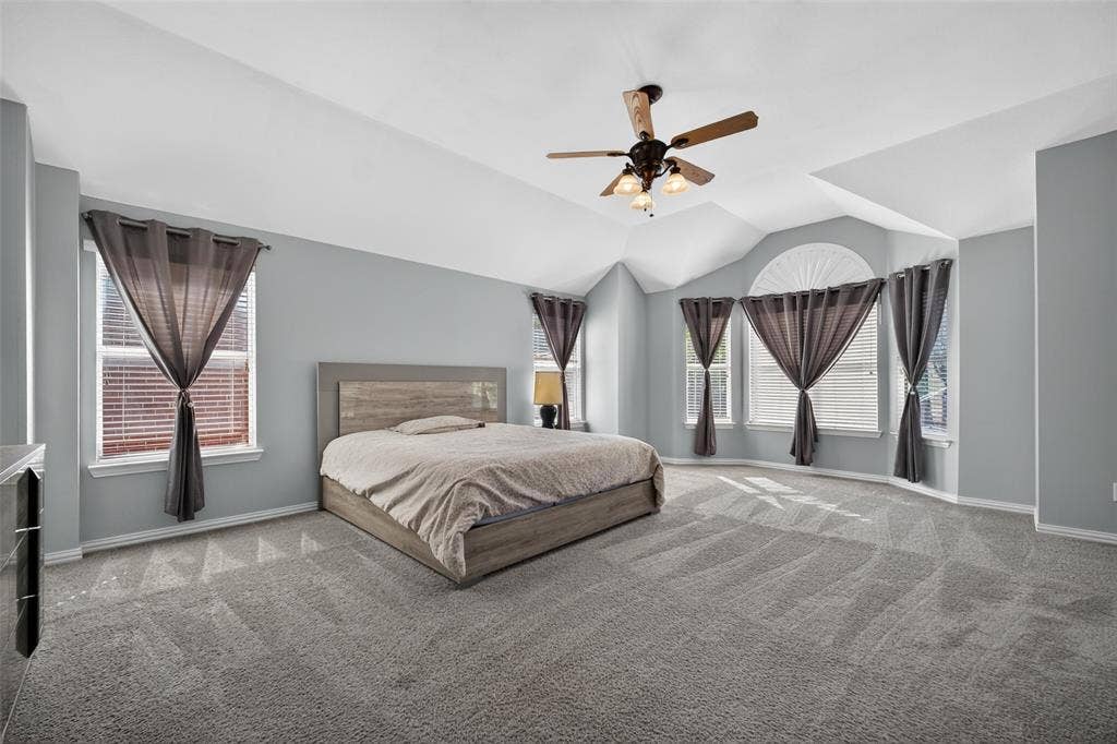 5726 Remington Drive, Garland, TX 75044 Vaulted ceilings with a ceiling fan, neutral wall paint, and windows featuring an arched top accent