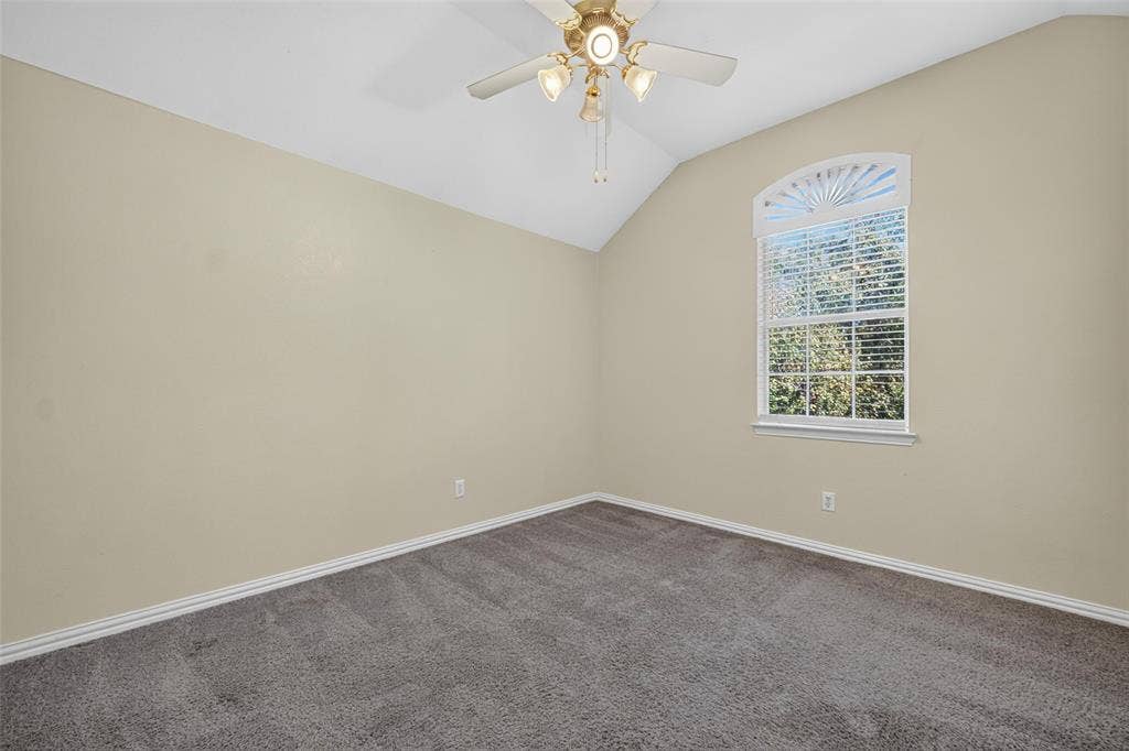 5726 Remington Drive, Garland, TX 75044 Vaulted ceilings, neutral wall tones, wall-to-wall carpeting, and an arched window with an integrated fan light fixture