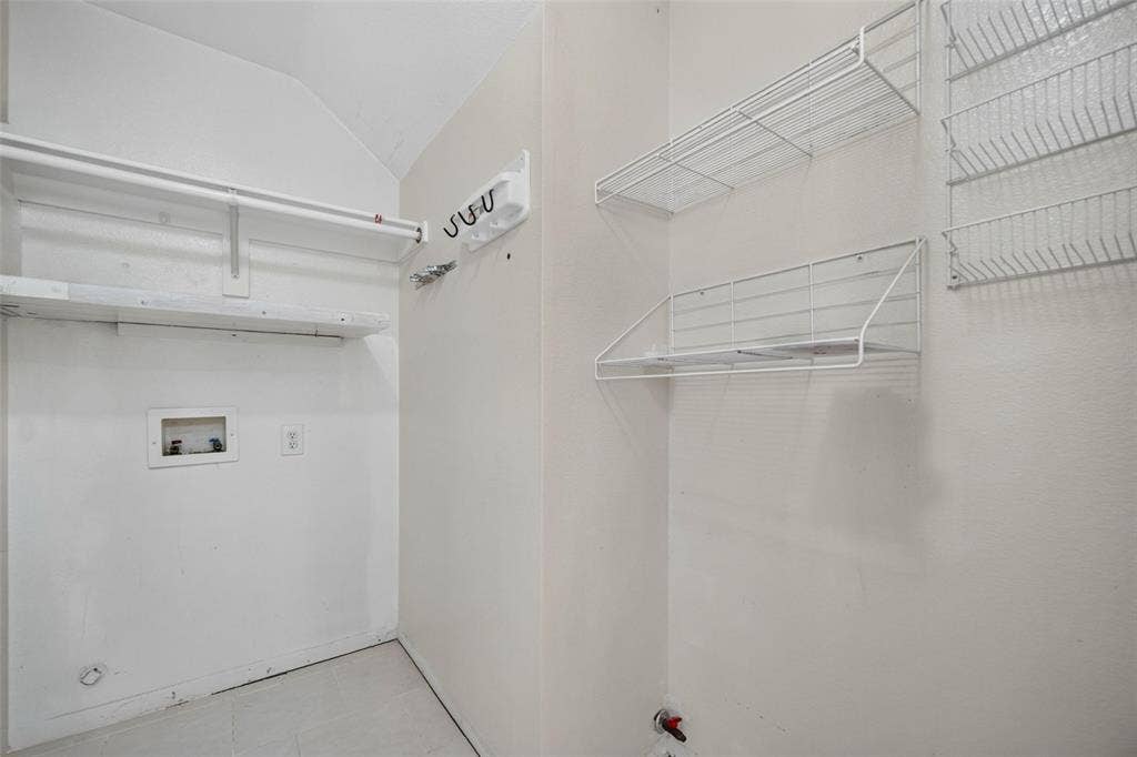 5726 Remington Drive, Garland, TX 75044 Utility area featuring built-in wire shelving, overhead storage racks, wall-mounted utility hooks, and dedicated water and electrical hookups