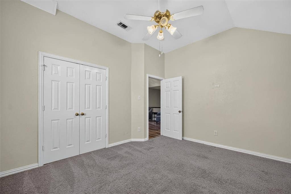 5726 Remington Drive, Garland, TX 75044 Vaulted ceilings, neutral wall palette, wall-to-wall carpeting, four-blade ceiling fan with integrated lighting, and dual-panel closet doors
