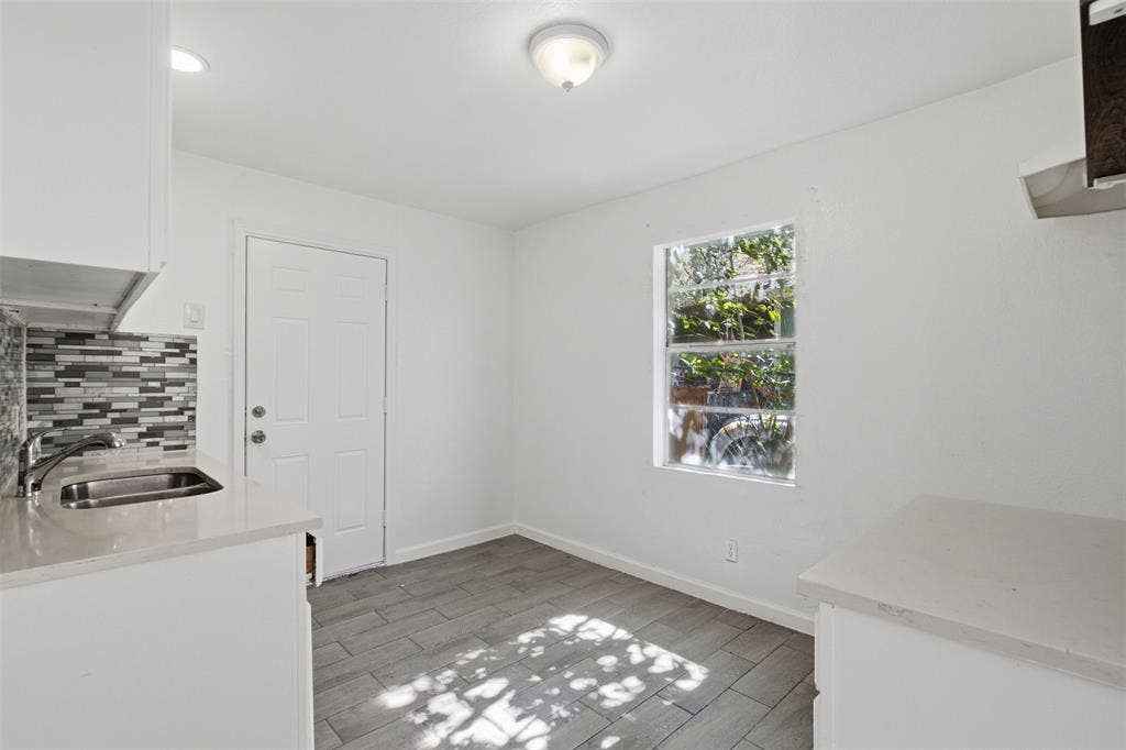 336 Bonnie View Road, Dallas, TX 75203 Kitchen space featuring tile flooring, quartz countertops, a stainless steel undermount sink, a multi-tone tile backsplash, and a single-hung window
