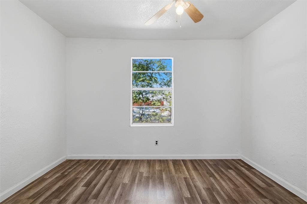 336 Bonnie View Road, Dallas, TX 75203 Interior room featuring wood-finish flooring, white walls, and a ceiling-mounted fan with integrated light fixture
