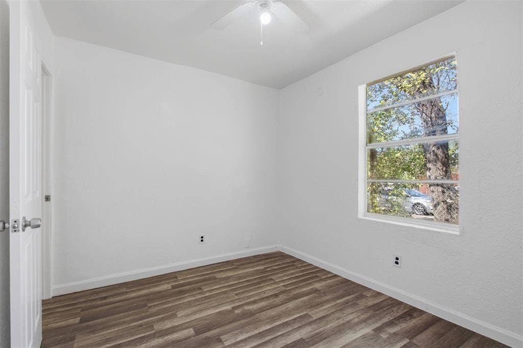 336 Bonnie View Road, Dallas, TX 75203 Interior room featuring wood-finish flooring, white walls, a ceiling fan with integrated lighting, and a multi-pane horizontal sliding window
