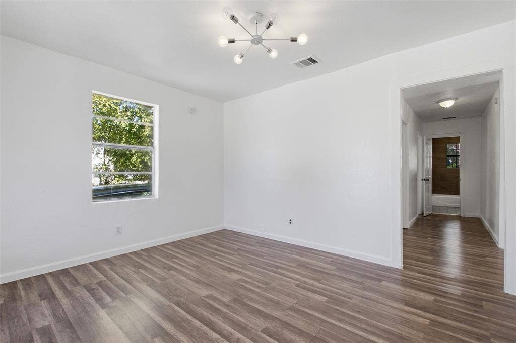 336 Bonnie View Road, Dallas, TX 75203 Room featuring wood-finish flooring, a contemporary six-arm chandelier, and a large window