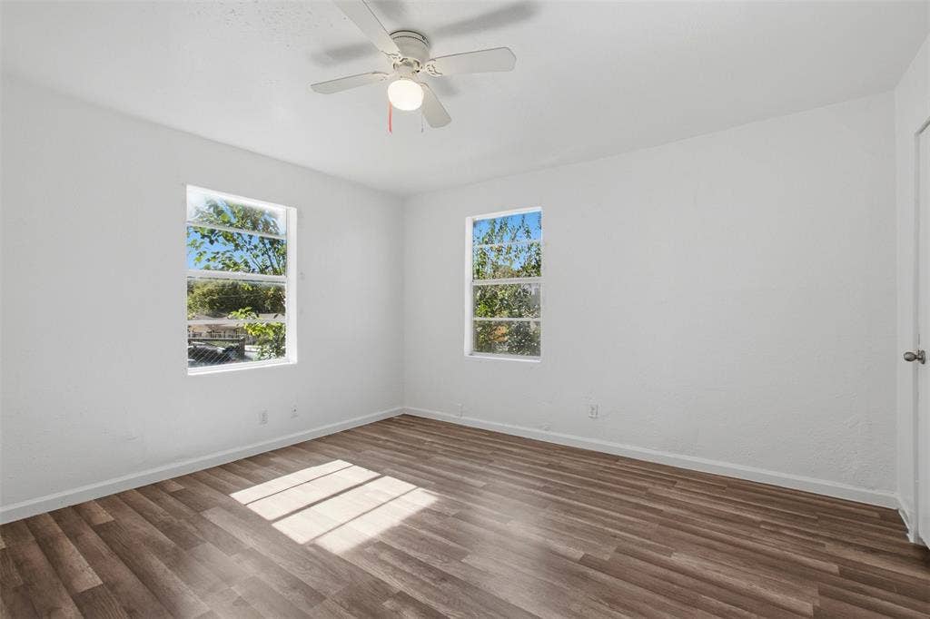 336 Bonnie View Road, Dallas, TX 75203 Room featuring wood-finish flooring, crisp white walls, dual windows, and a ceiling-mounted light fixture with a fan
