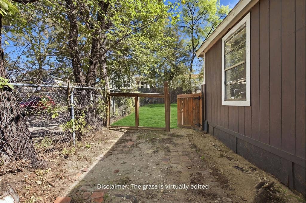 336 Bonnie View Road, Dallas, TX 75203 Exterior area featuring vertical siding, a brick-paved ground surface, mature trees, and a wooden gate
