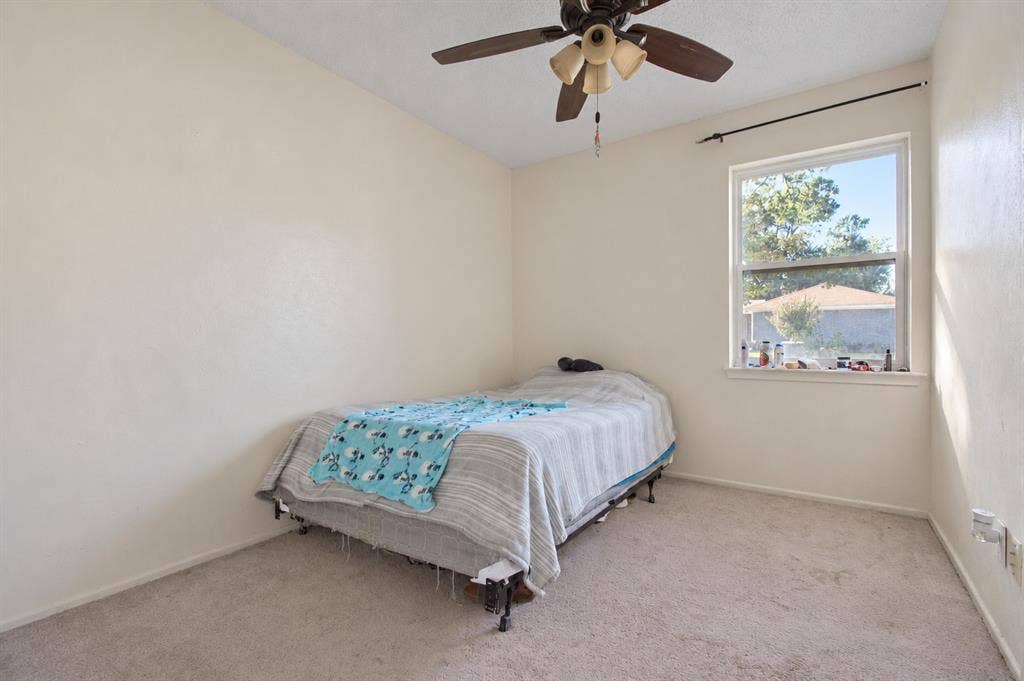 1910 R Avenue, Plano, TX 75074 Room featuring neutral carpeting, textured wall finish, and a ceiling-mounted light fixture with a fan