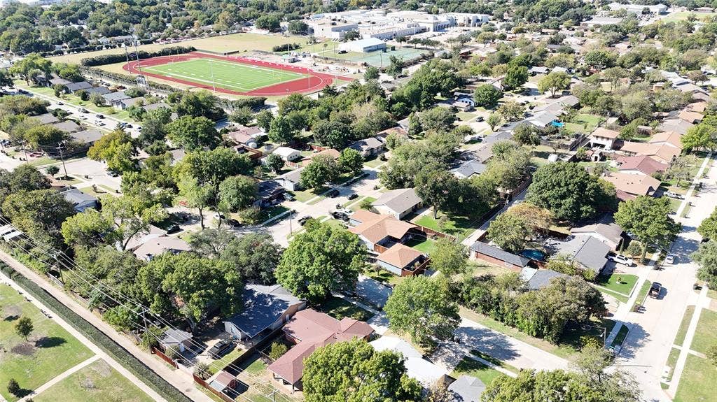 1910 R Avenue, Plano, TX 75074 Aerial perspective of a residential neighborhood featuring mature canopy trees, established landscaping, and proximity to athletic fields and track facilities