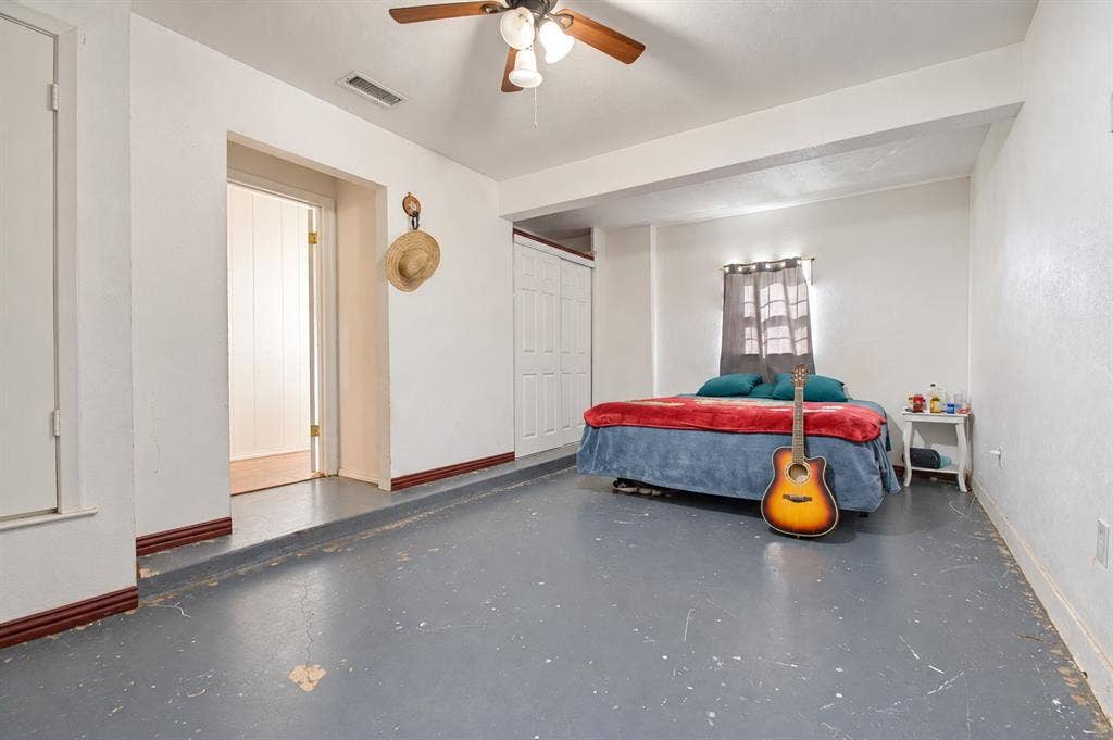 1910 R Avenue, Plano, TX 75074 Multi-level room featuring painted concrete flooring, bi-fold closet doors, and a ceiling fan with integrated lighting