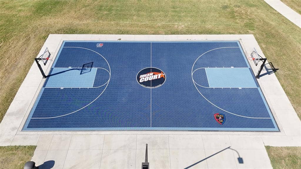 1910 R Avenue, Plano, TX 75074 Outdoor basketball court with a specialized synthetic surface, dual adjustable-height goal systems, concrete perimeter, and painted boundary markings