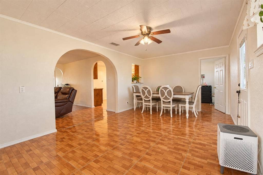 1910 R Avenue, Plano, TX 75074 Open living area featuring ceramic tile flooring, distinctive arched doorways, a ceiling fan with light fixture, and a pass-through opening