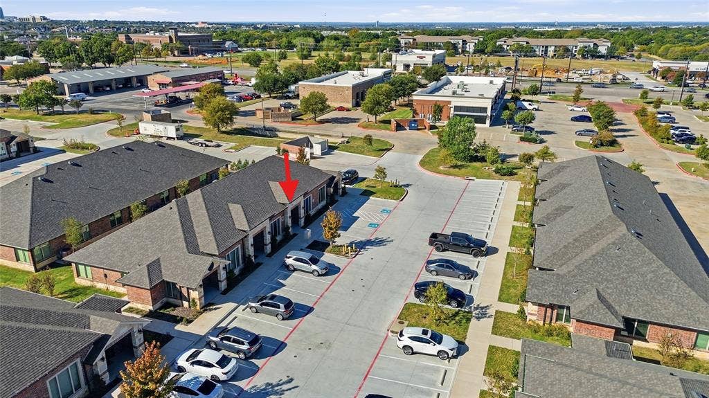 Commercial building featuring brick and masonry exterior, architectural shingle roofing, and dedicated concrete surface parking