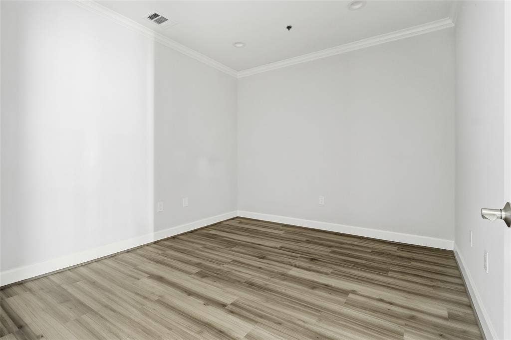 Interior room featuring wood-finish flooring, crown molding, and recessed lighting