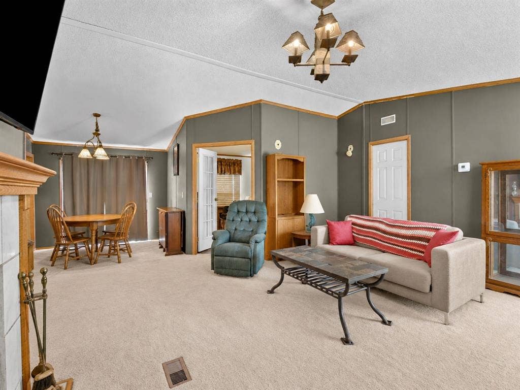 1528 CR 697, Farmersville, TX 75442 Vaulted ceilings, built-in shelving, a fireplace with a wood mantel, multi-light chandeliers, and French-style interior doors