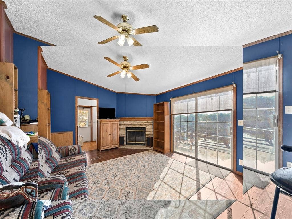 1528 CR 697, Farmersville, TX 75442 Living area featuring a stone-surround fireplace, built-in shelving, sliding glass doors, and a ceiling fan with integrated lighting