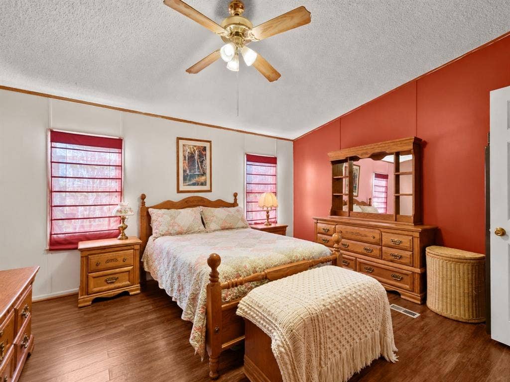 1528 CR 697, Farmersville, TX 75442 Vaulted ceiling with a centrally mounted wood-tone ceiling fan and light fixture, wood-finish flooring, and dual windows