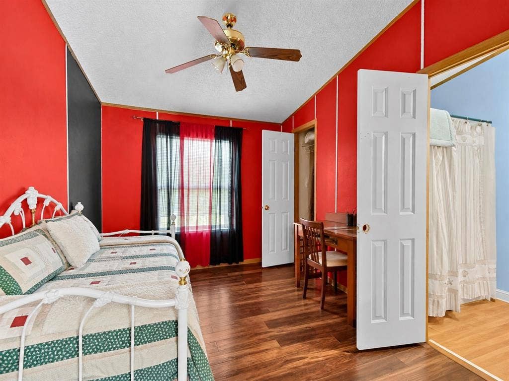 1528 CR 697, Farmersville, TX 75442 Wood-finish flooring, brass-finish ceiling fan with integrated lighting, and multiple interior six-panel doors