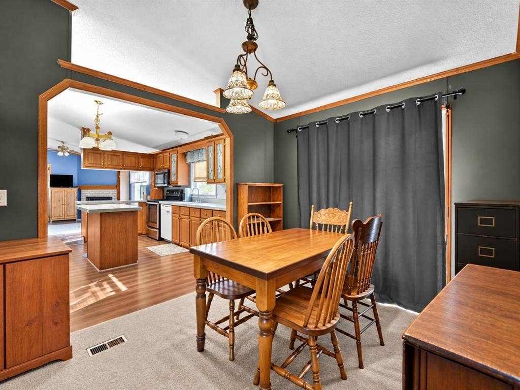 1528 CR 697, Farmersville, TX 75442 Dining area featuring a three-light decorative chandelier, wood-finish flooring, and large pass-through opening