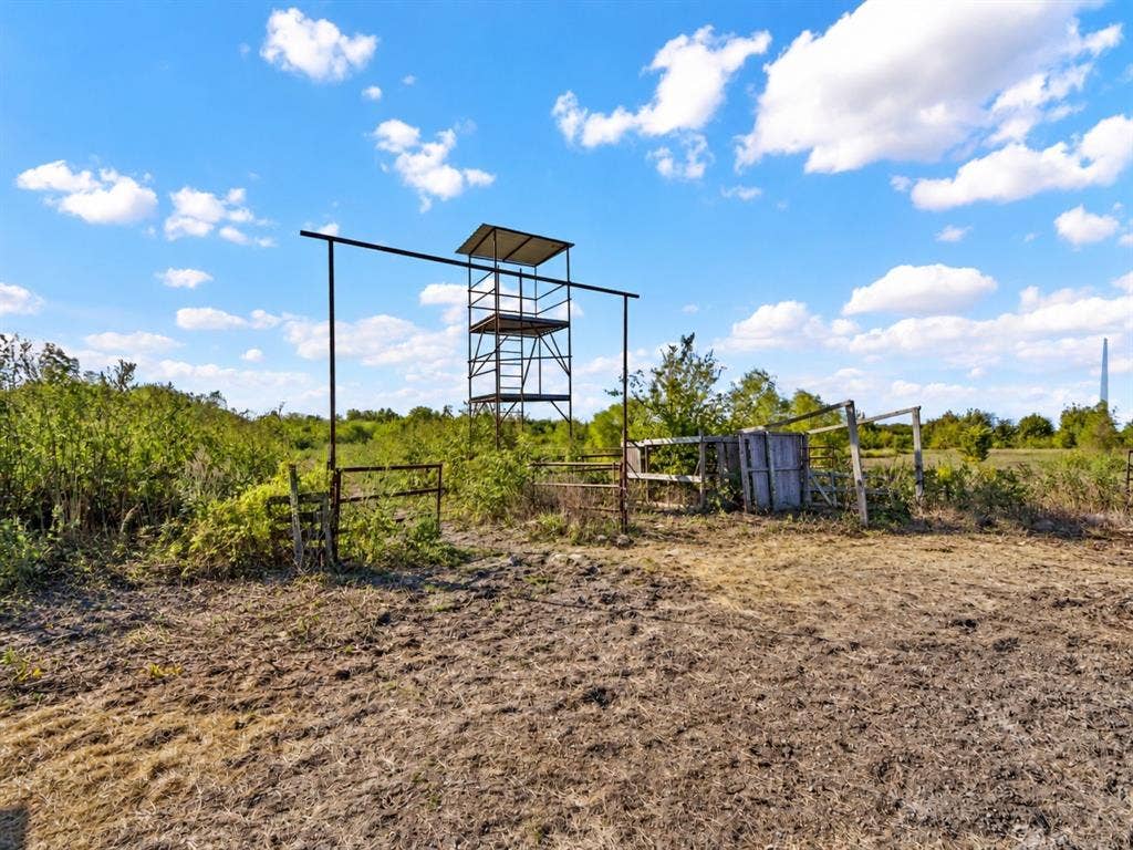 1528 CR 697, Farmersville, TX 75442 Expansive land featuring a metal observation tower, metal perimeter fencing, and rural vegetation
