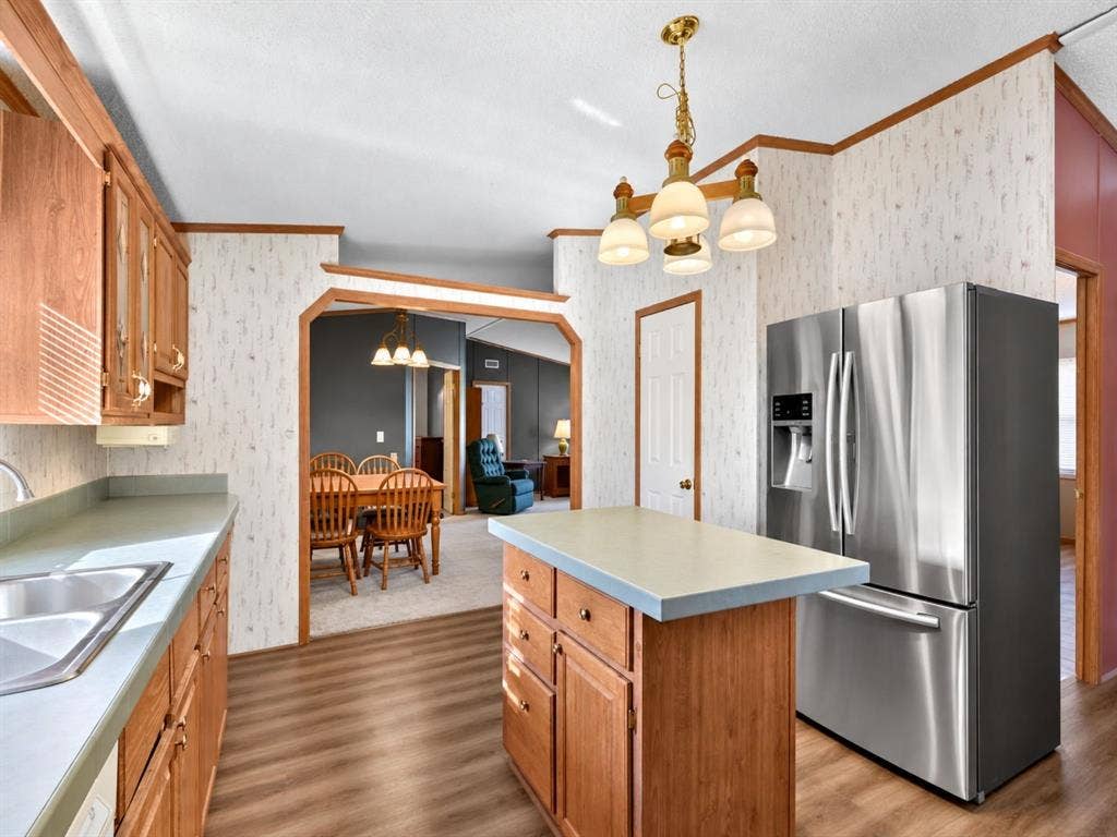 1528 CR 697, Farmersville, TX 75442 Kitchen featuring natural wood cabinetry, a center island with solid surface countertops, stainless steel French-door refrigerator, and wood-finish flooring