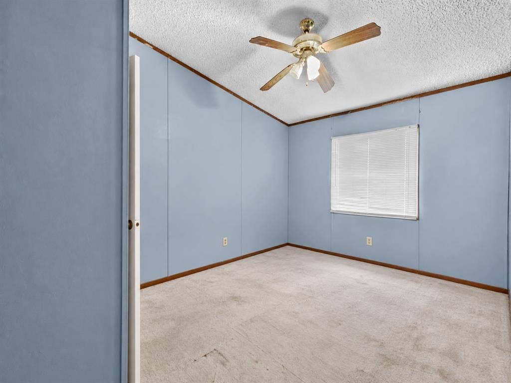 1528 CR 697, Farmersville, TX 75442 Room featuring neutral carpeting, panel walls, a ceiling fan with integrated light fixture, and a window with blinds