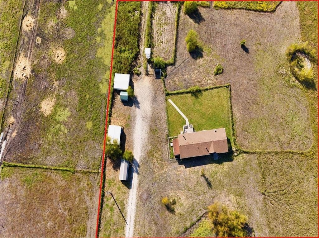 1528 CR 697, Farmersville, TX 75442 Aerial view featuring expansive acreage, a gravel driveway, multiple detached structures, and a residential building with a shingled roof