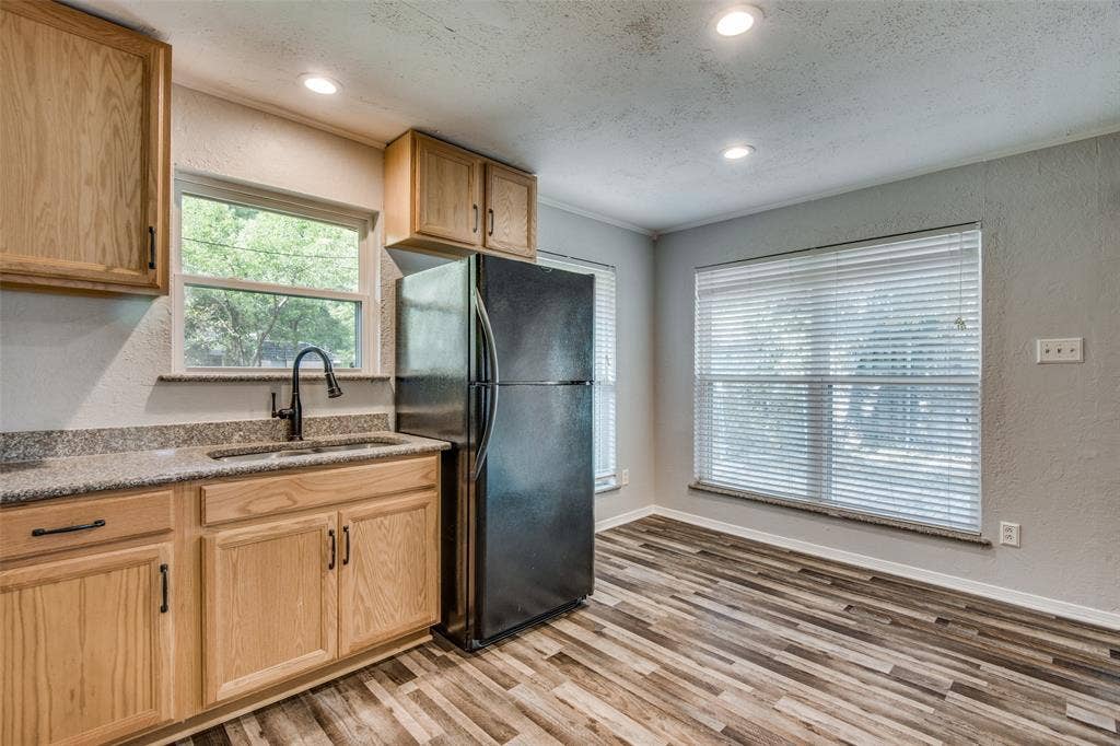 2131 Onetta Drive, Irving, TX 75061 Kitchen featuring light wood-finish cabinetry, stone-texture countertops, wood-finish flooring, a high-arc faucet, and recessed lighting